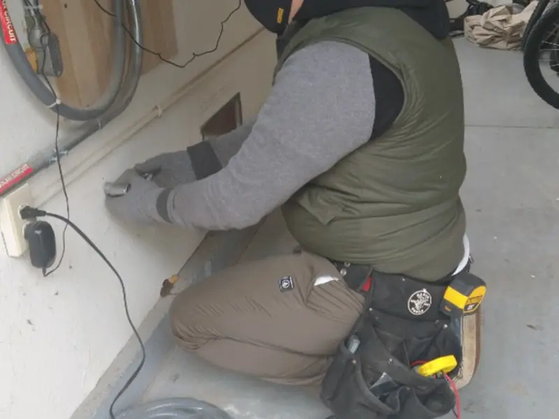 Electrician performing outlet wiring in a Warner Robins garage